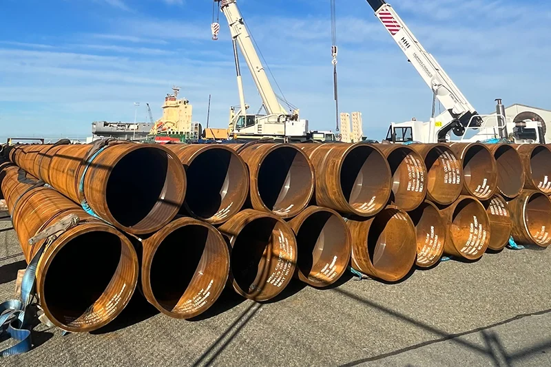 Long and large steel pipes piled up and placed outdoor