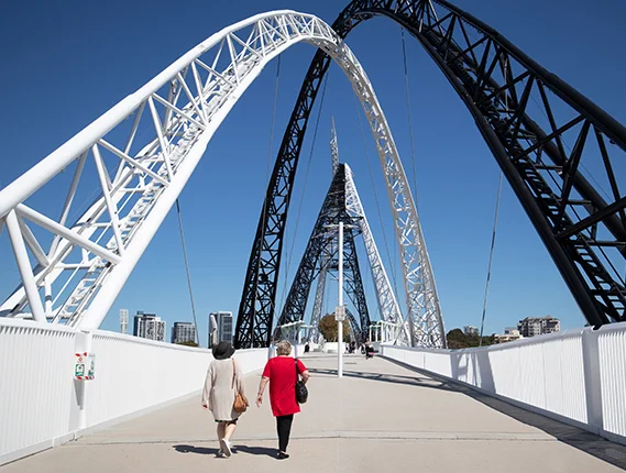 Two ladies roaming on a architectural bridge